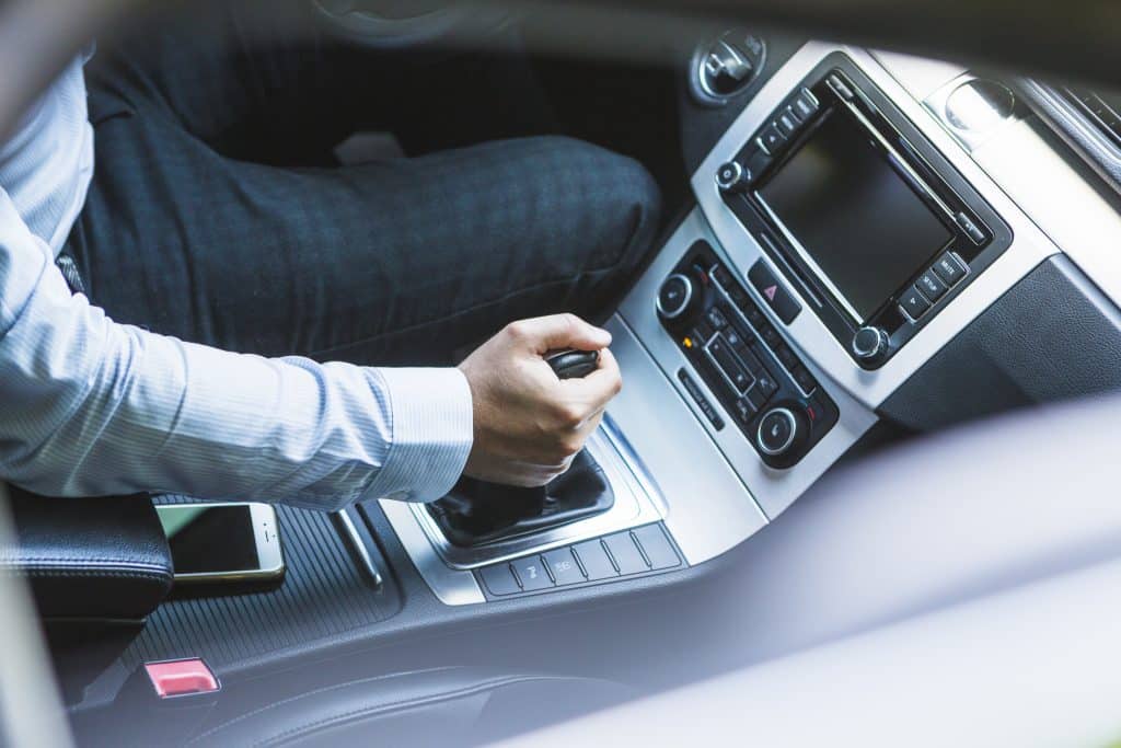 Manuel vitesli bir aracın vitesini değiştiren sürücü; ECU Global'in motor ömrünü ve sürüş güvenliğini ön planda tutan profesyonel hizmet anlayışını temsil eden görsel.
