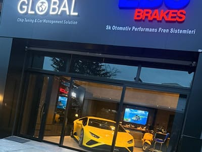 ECU Global chip tuning ve araç yönetim çözümleri tabelası önünde duran, performans ve yazılım işlemi tamamlanmış müşteri aracı.
