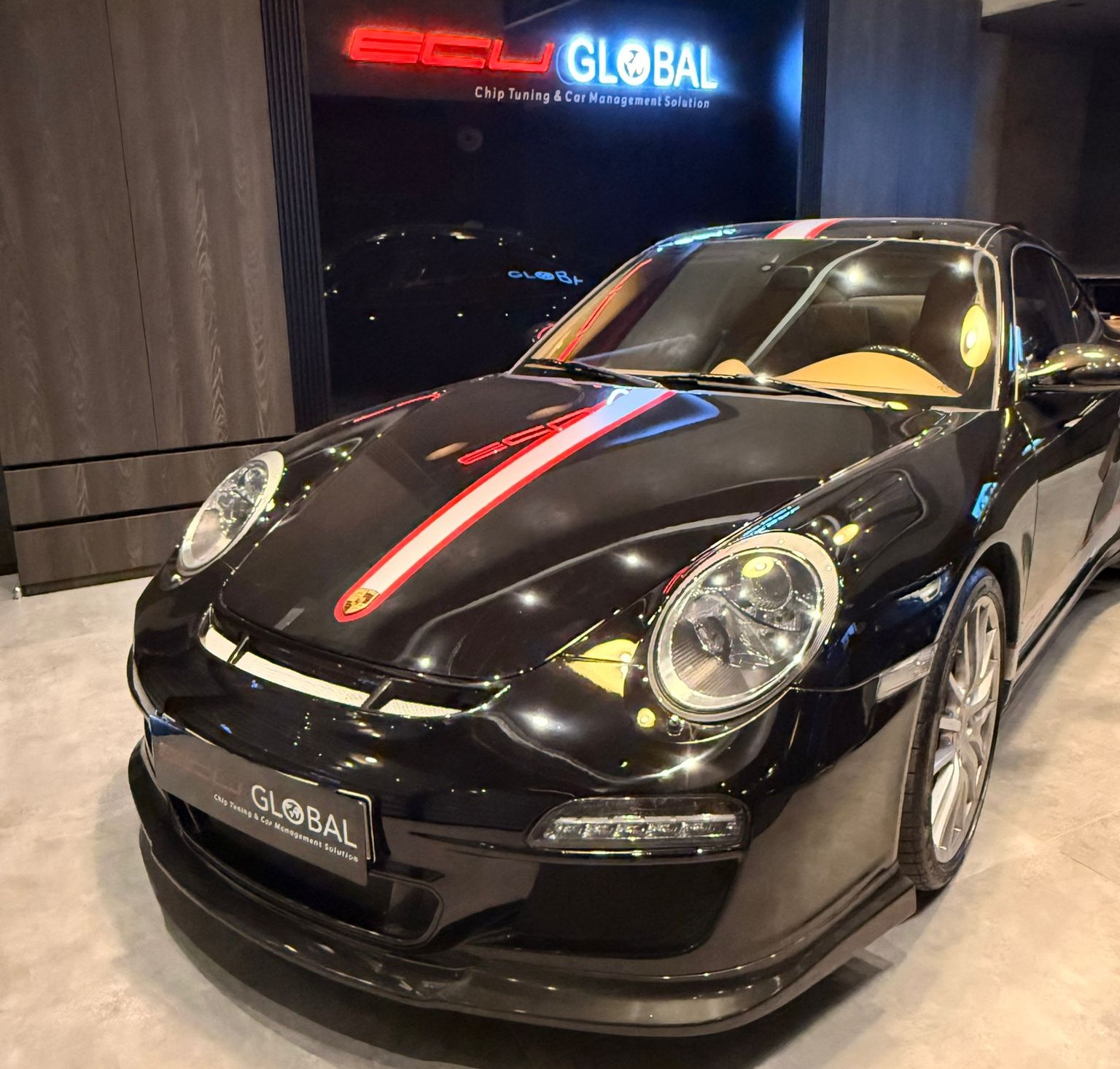 ECU Global servisinde performans artırma ve chip tuning işlemi için bekleyen siyah Porsche 911 spor otomobil.